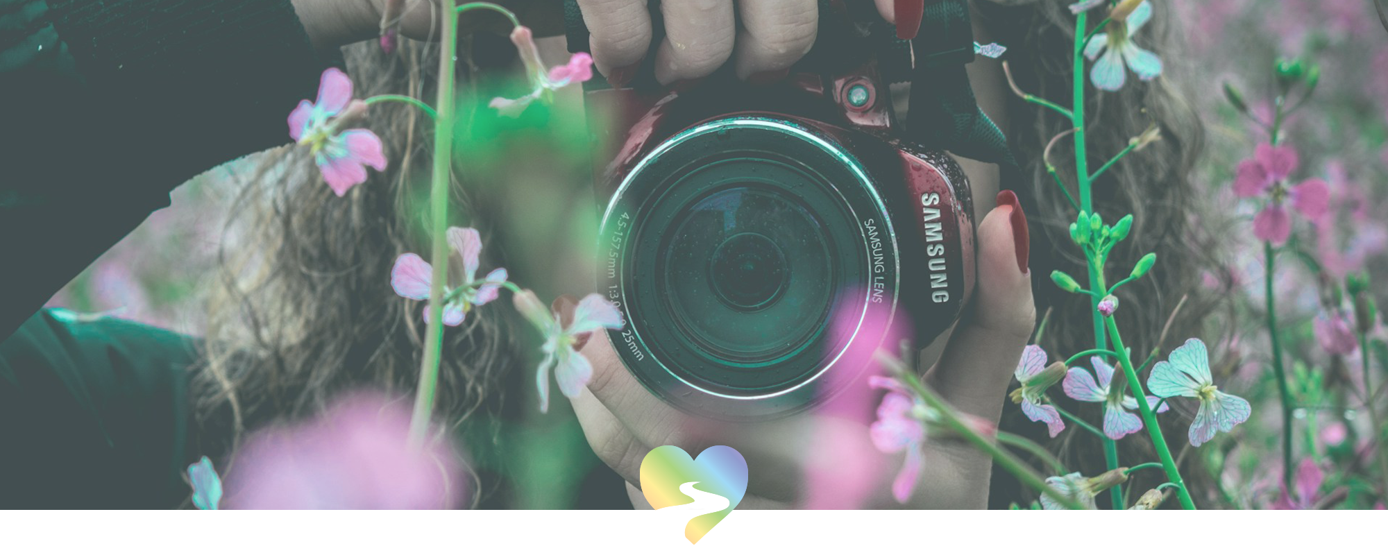 close-up of woman with camera surrounded by flowers