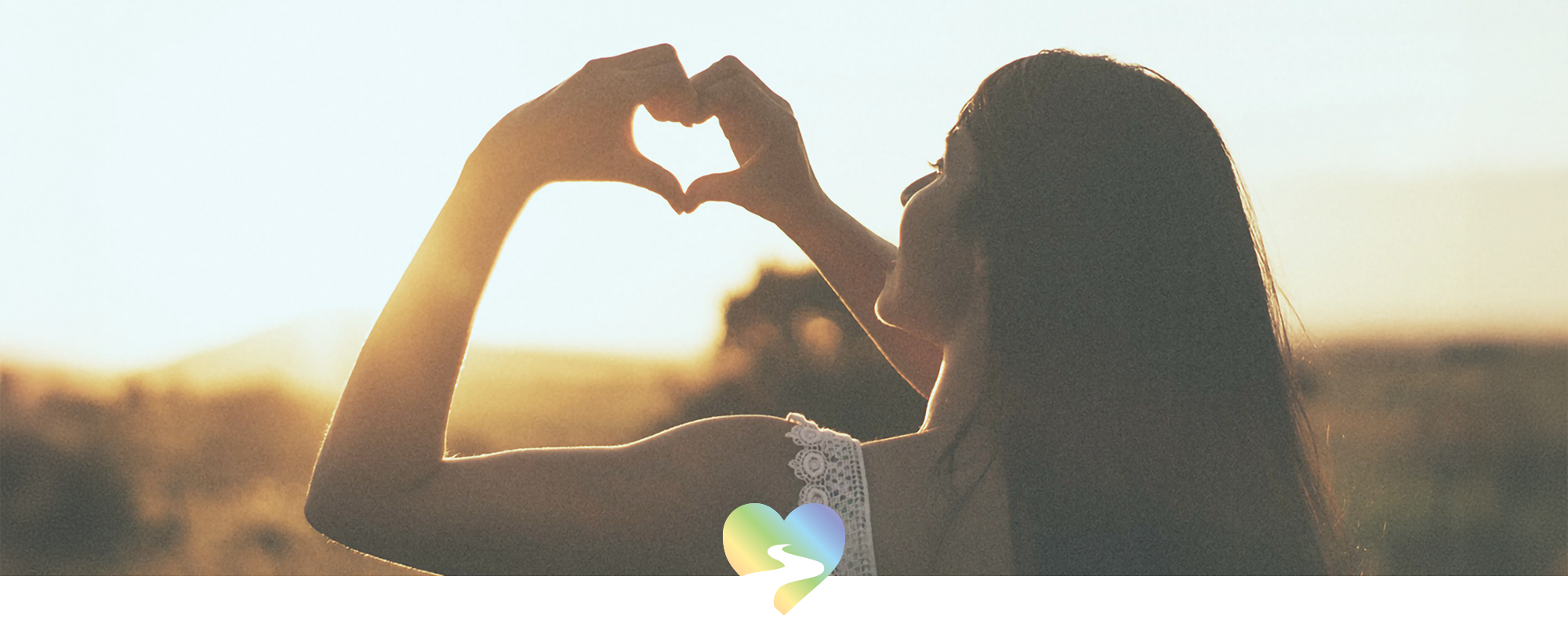 woman forming heart shape in sunlight symbolizing spiritual healing and inner beauty