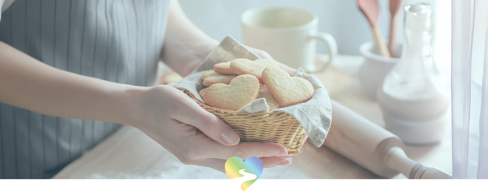 female hands holding a basket of heart shaped cookies