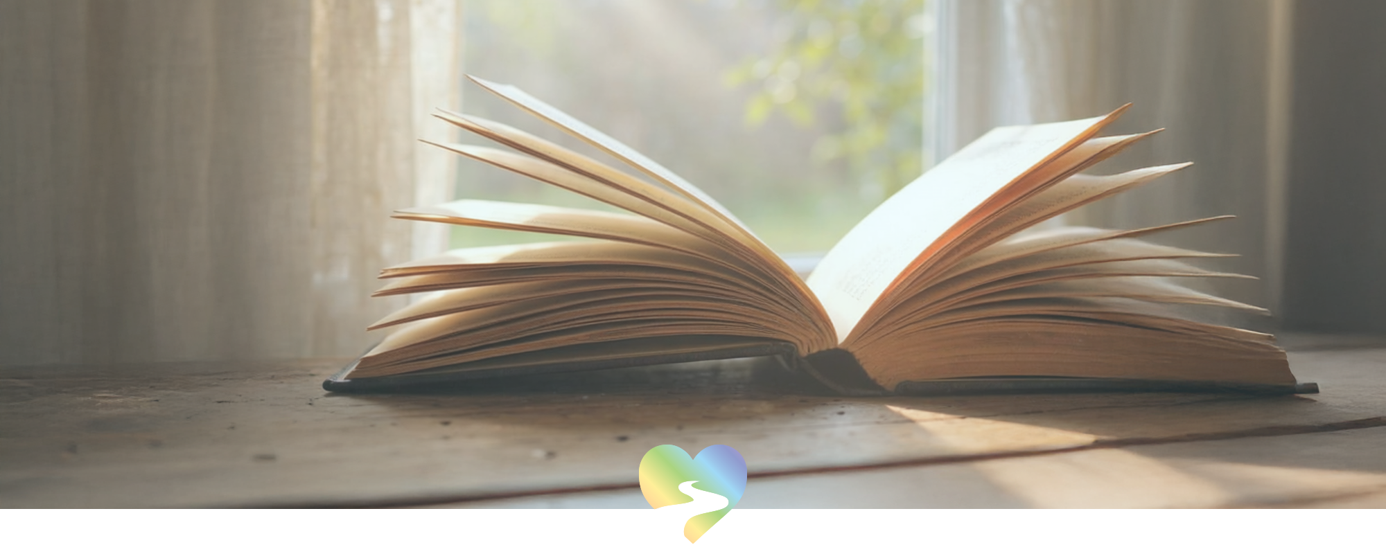 open book lying on a wooden table near a window – story behind Your Spirit Journey