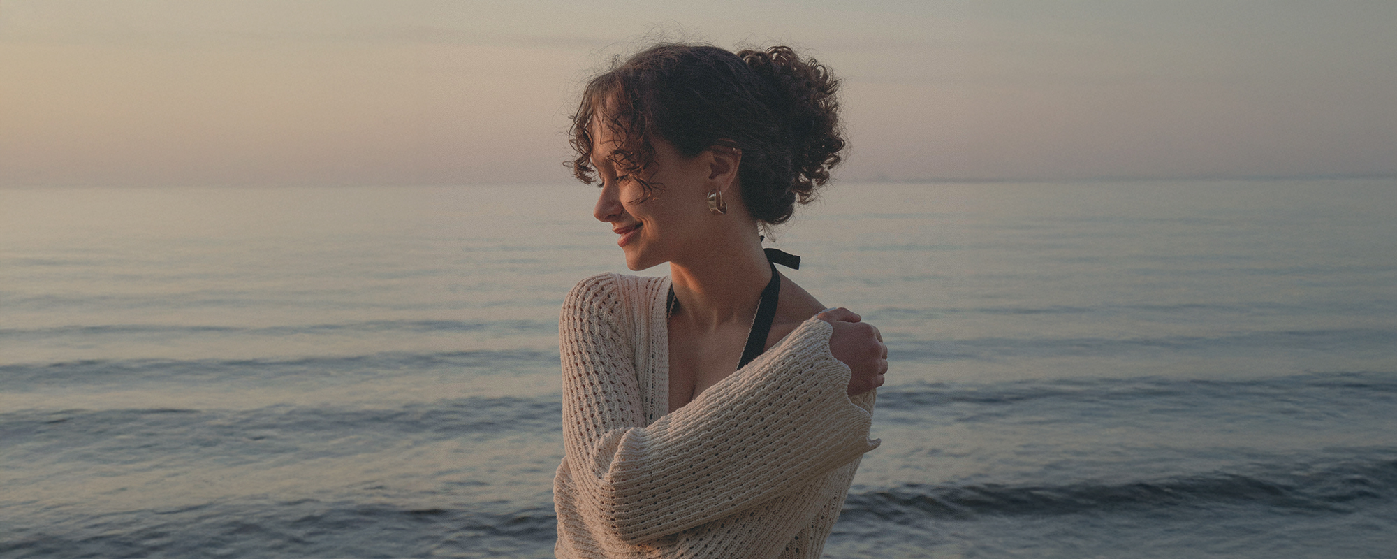 woman standing at the sea embracing herself symbolizing inner beauty